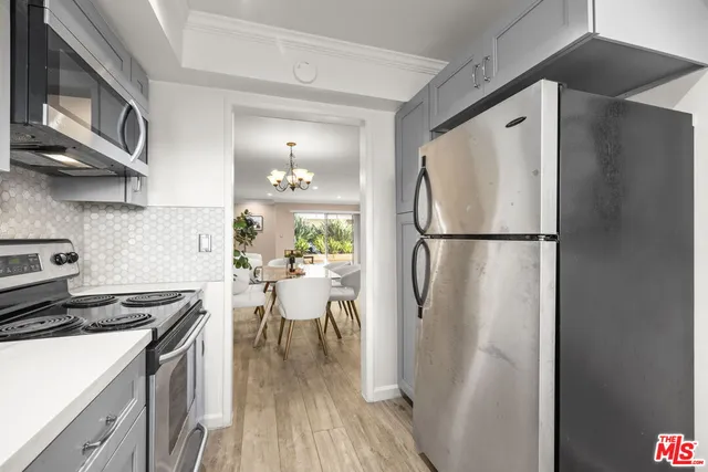 a kitchen with stainless steel appliances granite countertop a refrigerator a stove top oven a sink and dishwasher