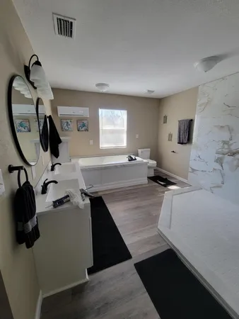 a view of a kitchen with kitchen island a sink wooden floor and a large window