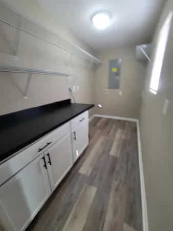 a kitchen with granite countertop white cabinets and sink