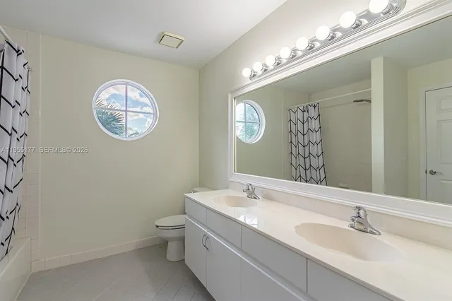 an empty room with a ceiling fan and window