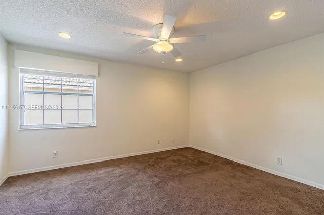 a kitchen with granite countertop a white cabinets and window