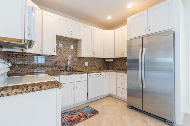 a kitchen with stainless steel appliances granite countertop a refrigerator sink and cabinets