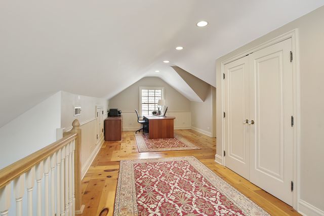 a view of a hallway with wooden floor and windows