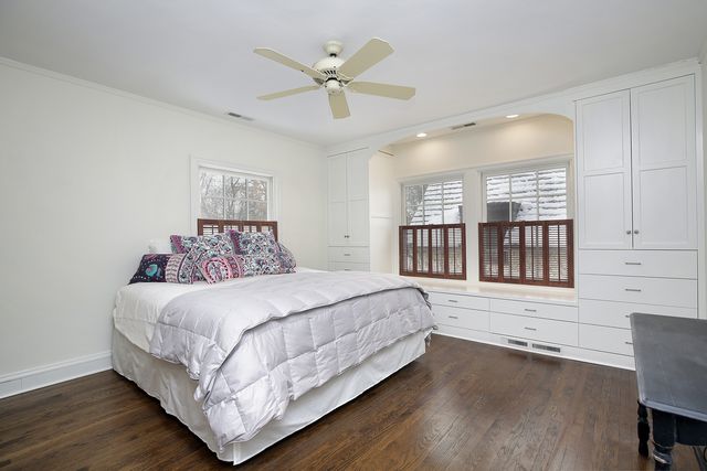 a bedroom with a large bed chandelier and a window
