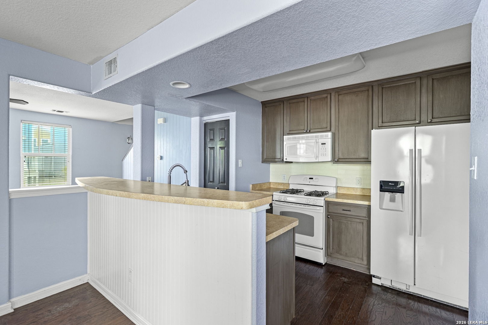 202 Trestle Tree San Marcos, TX 78666 - Photo 9 of 22 a kitchen with stainless steel appliances granite countertop a refrigerator a stove a sink and white cabinets with wooden floor