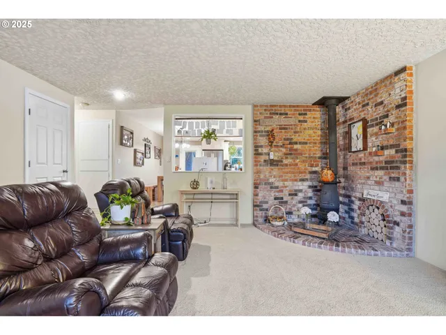 a kitchen with kitchen island a large window cabinets a sink a stove and a refrigerator