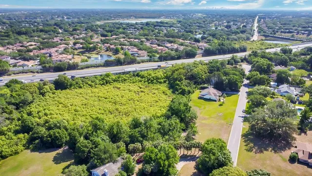 an aerial view of a residential houses with a yard and lake view