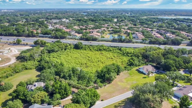 an aerial view of residential houses with outdoor space and trees