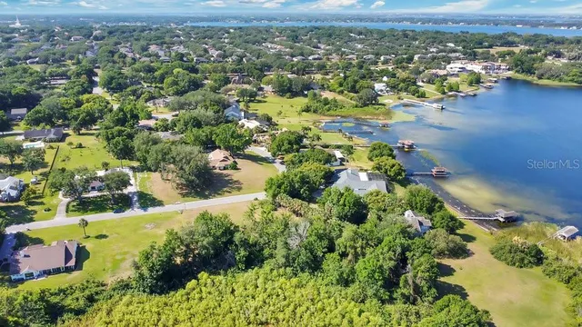 an aerial view of residential houses with outdoor space and trees