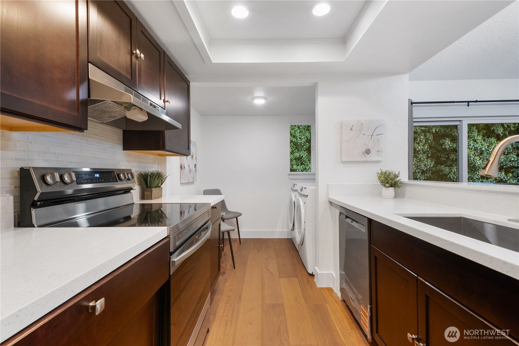 14401 Southeast Petrovitsky Road, Unit B209 Renton, WA 98058 - Photo 4 of 35 a kitchen with stainless steel appliances a sink dishwasher a stove top oven a refrigerator with wooden floor