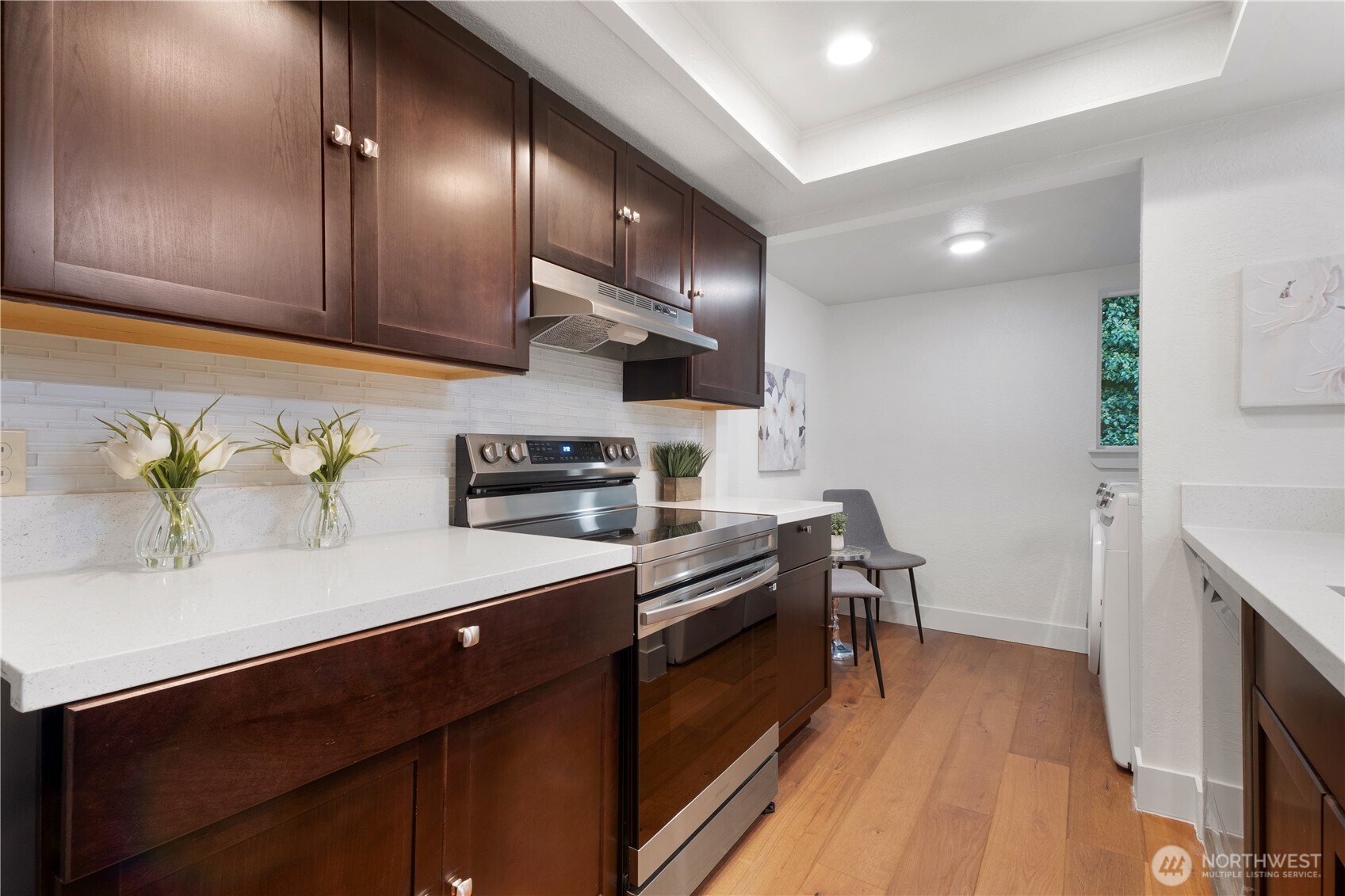 14401 Southeast Petrovitsky Road, Unit B209 Renton, WA 98058 - Photo 5 of 35 a kitchen with stainless steel appliances granite countertop a sink a stove and a wooden floors