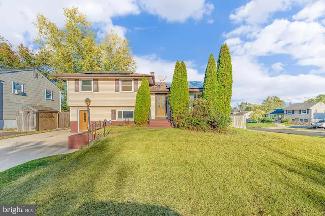 a view of a house with a big yard and large tree
