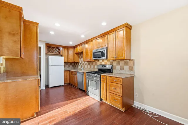 a kitchen with a refrigerator and a stove top oven