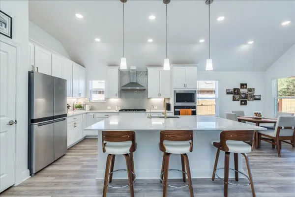 a kitchen with refrigerator and chairs