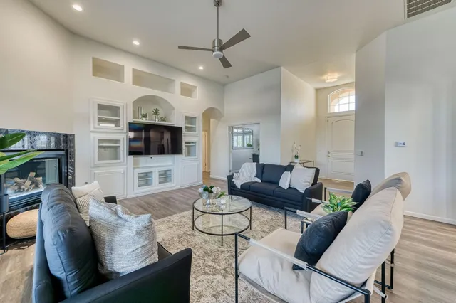 a large living room with stainless steel appliances granite countertop a couch and a wooden floor