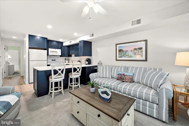 a living room with furniture and kitchen view