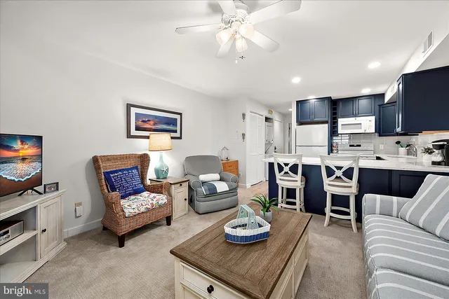 a living room with furniture kitchen view and a flat screen tv