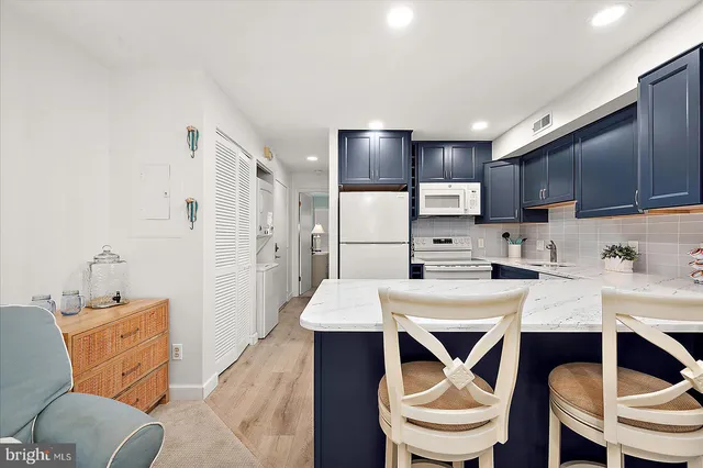 a kitchen with a dining table chairs sink refrigerator and cabinets