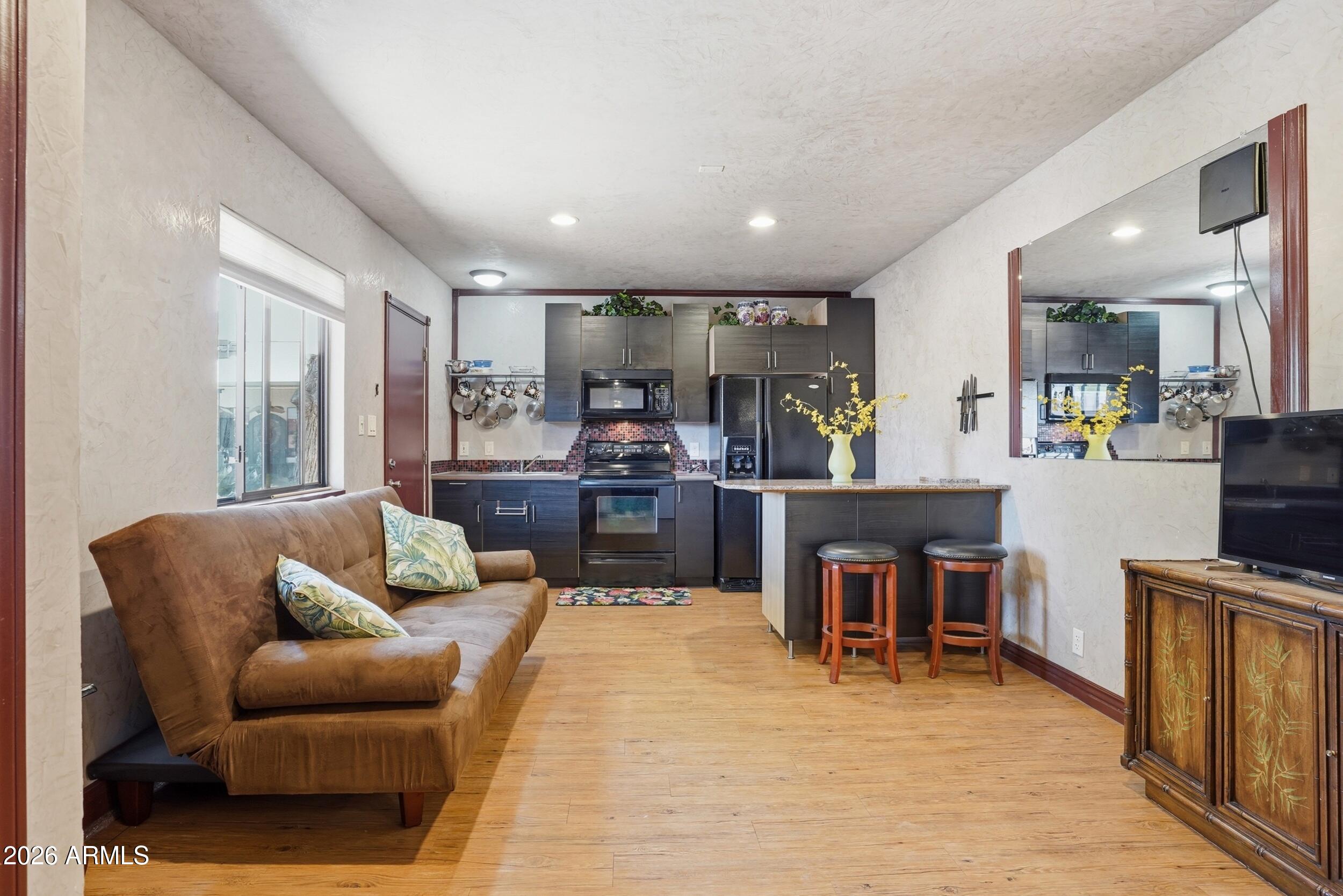 6334 East Albany Street Mesa, AZ 85205 - Photo 51 of 72 a living room with stainless steel appliances kitchen island granite countertop furniture and a kitchen view