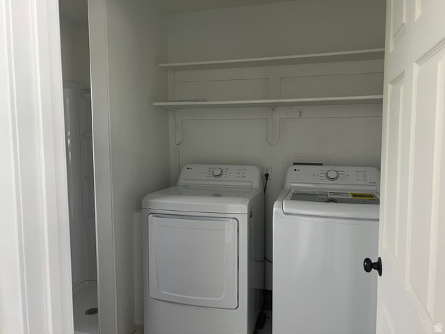 875 Cedar Hollow Road Lehi, UT 84043 - Photo 14 of 76 Built-in shelving, white washer and dryer, white paneled door, black door hardware, and white shower stall
