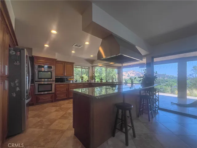 a large kitchen with lots of counter space wooden cabinets and stainless steel appliances