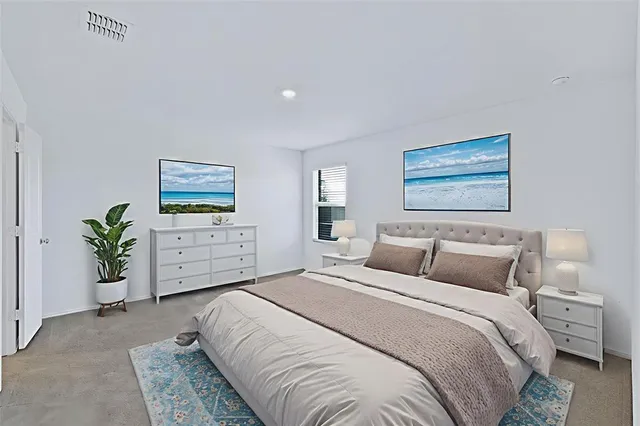 a bedroom with a large bed and a potted plant