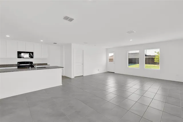 a view of kitchen with kitchen island stainless steel appliances a sink and cabinets