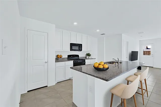 a kitchen with stainless steel appliances granite countertop a sink and a refrigerator