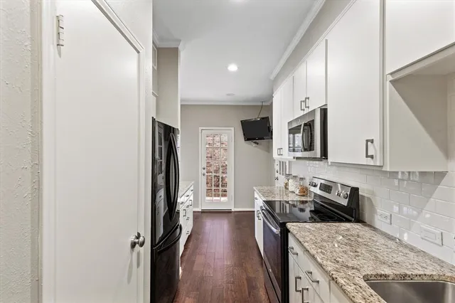 a kitchen with stainless steel appliances granite countertop a stove a sink and a refrigerator