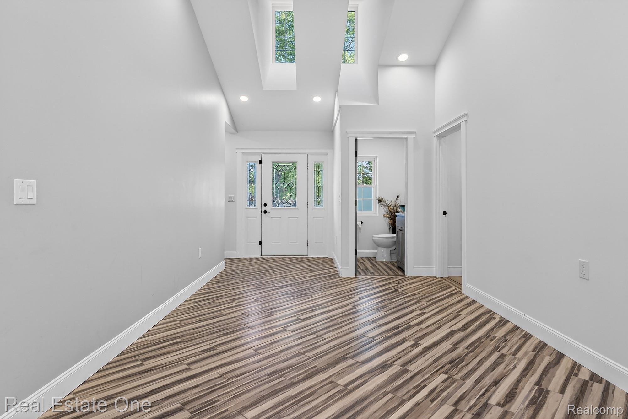 26987 Crawford Road Romulus, MI 48174 - Photo 6 of 51 Spacious entryway featuring unique wood-finish flooring, recessed lighting, and vaulted ceilings with skylights