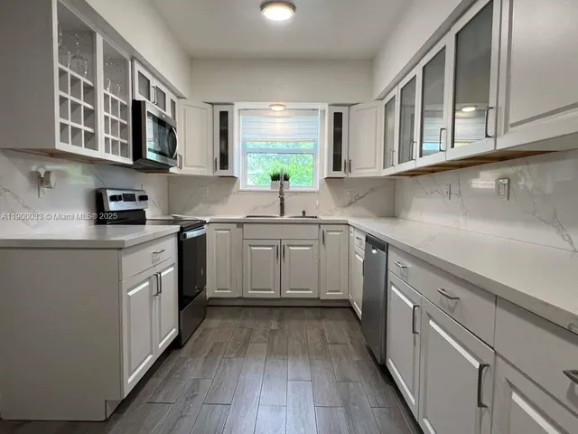 a kitchen with stainless steel appliances granite countertop a sink and a microwave