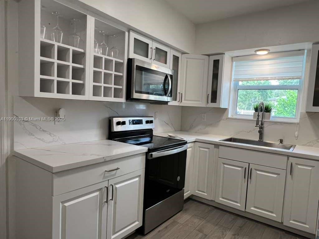 1430 Northeast 149th Street Miami, FL 33161 - Photo 14 of 51 a kitchen with stainless steel appliances granite countertop a sink and a microwave