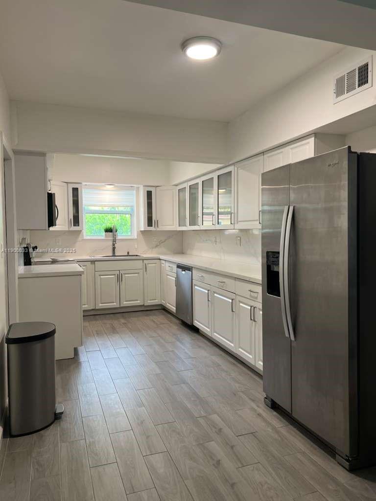1430 Northeast 149th Street Miami, FL 33161 - Photo 15 of 51 a kitchen with stainless steel appliances a refrigerator sink and cabinets