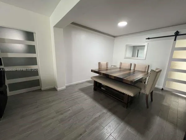 a bedroom with a bed and a flat tv screen on dresser