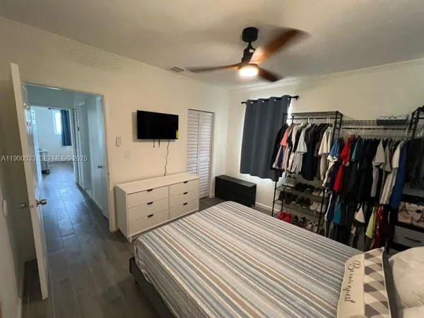 a spacious bedroom with a bed and a flat screen tv