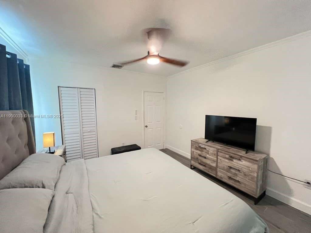 1430 Northeast 149th Street Miami, FL 33161 - Photo 29 of 51 a bedroom with a bed and a flat screen tv