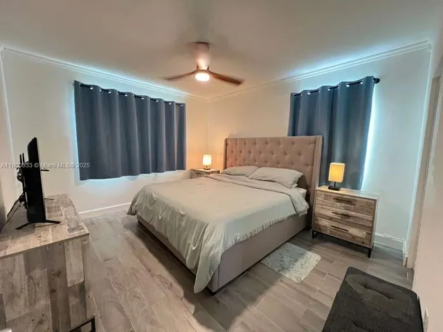a spacious bedroom with a bed and a flat screen tv