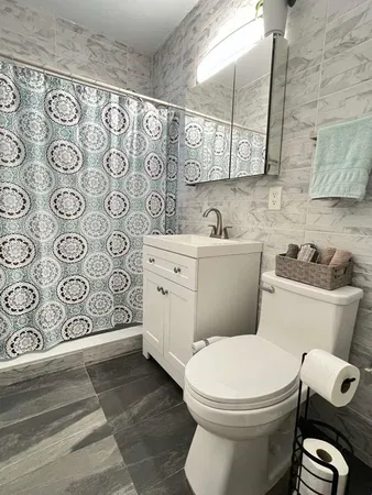 a bathroom with a sink toilet and window