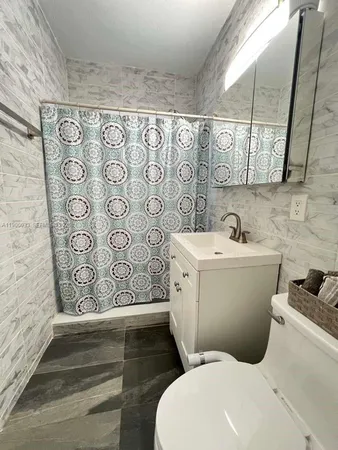 a bathroom with a shower a toilet and a bathtub