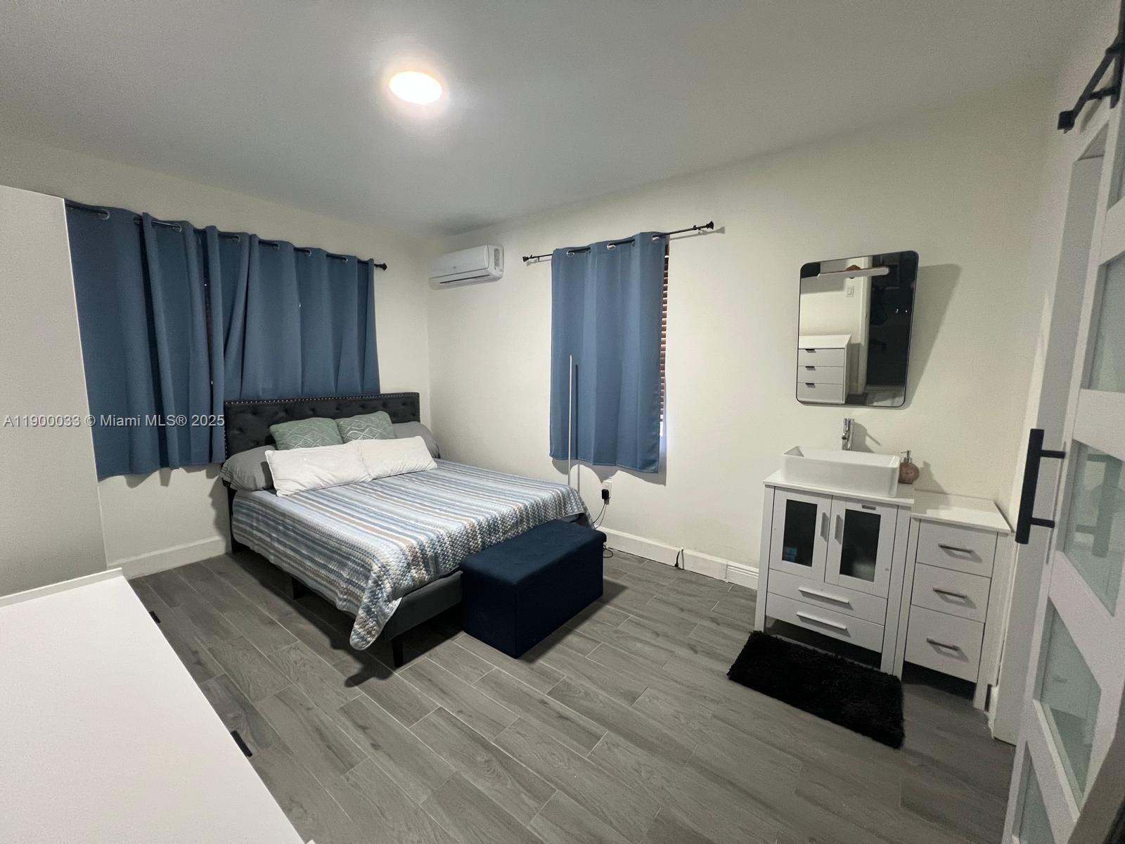 1430 Northeast 149th Street Miami, FL 33161 - Photo 35 of 51 a bedroom with a bed a flat screen tv and dresser