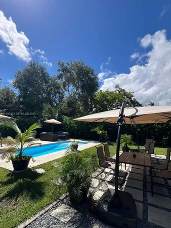 a view of pool with lawn chairs and a yard