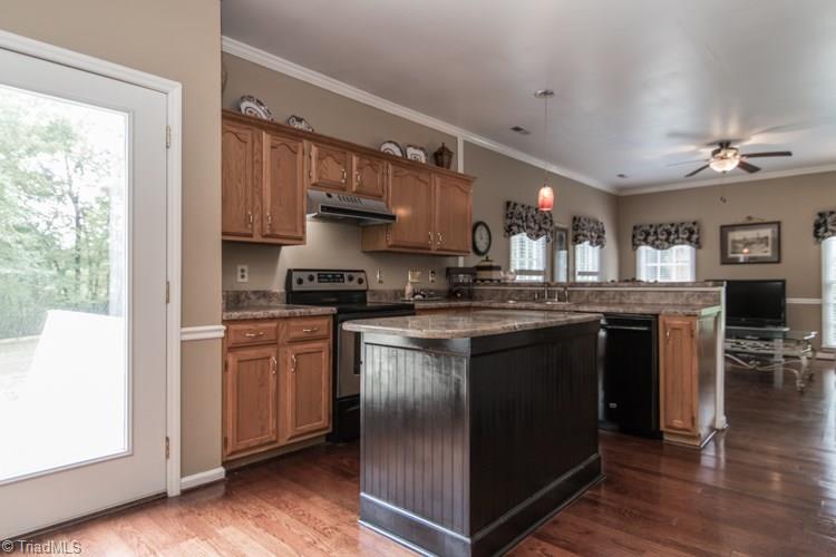 3325 Timberwolf Avenue High Point, NC 27265 - Photo 7 of 30 Kitchen with hardwoods and custom island and patio doors to the deck and backyard