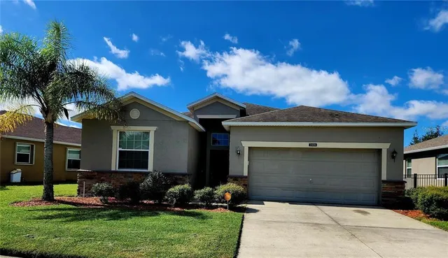 a front view of a house with a yard and garage