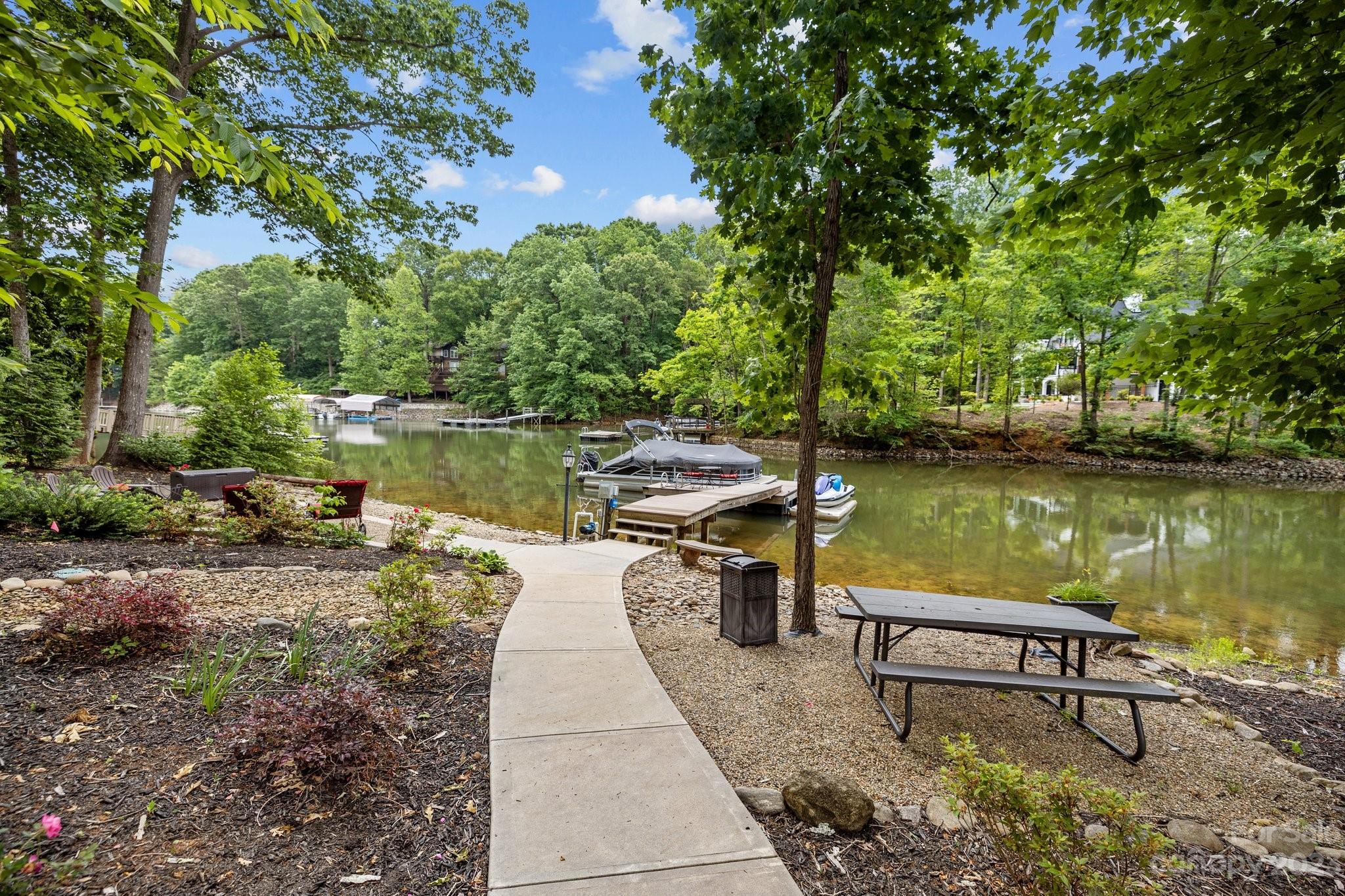 7478 Bankhead Road Denver, NC 28037 - Photo 43 of 48 a view of a lake with a bench and trees