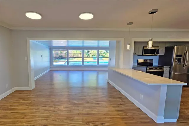 a large room with wooden floor and a large window