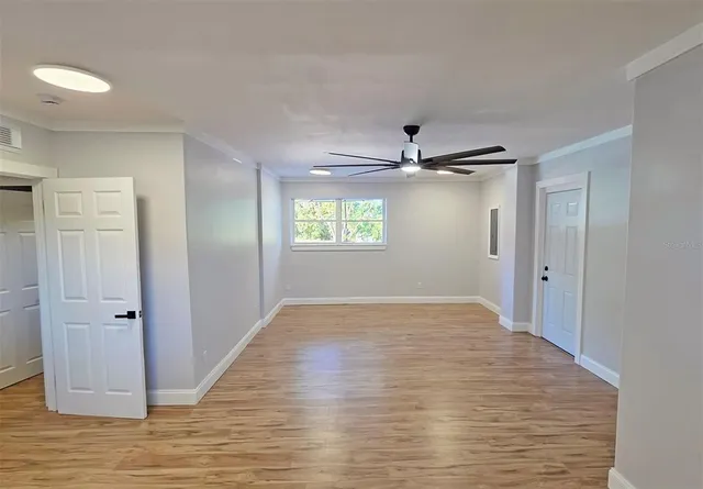 a view of empty room with wooden floor and window