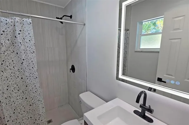 a bathroom with a sink toilet and shower