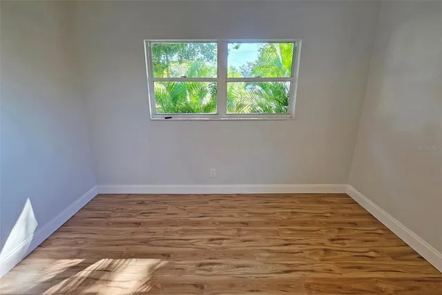 a view of a room with wooden floor and window