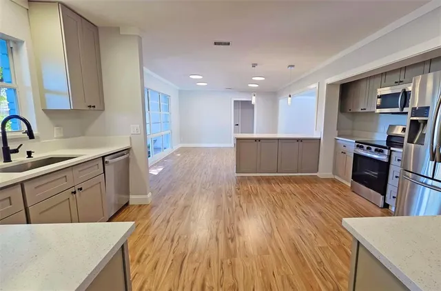 a kitchen with stainless steel appliances wooden floors and wooden cabinets