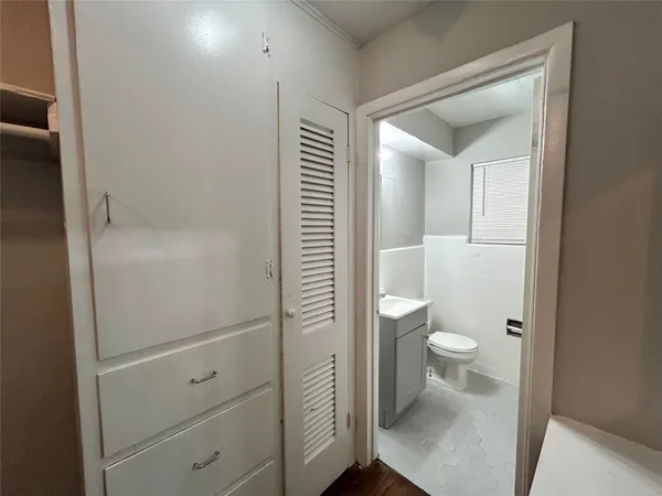 a bathroom with a granite countertop toilet and a sink
